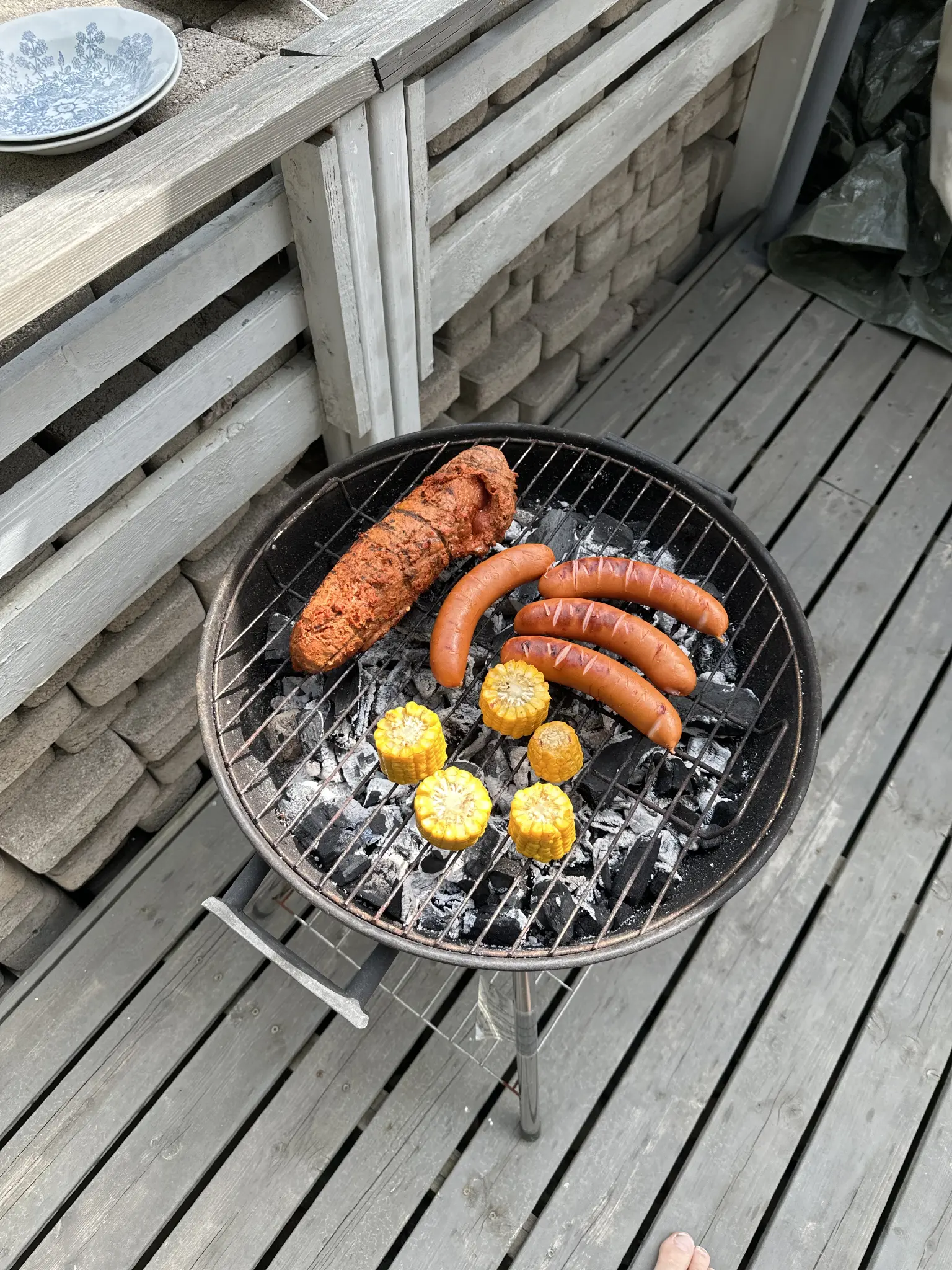 hiiligrillissä makkaraa, maissia ja lihalötkö